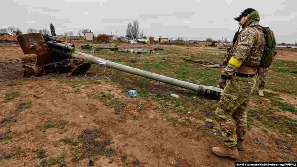 Військовий ЗСУ дивиться на знищену російську воєнну техніку неподалік аеропорту «Херсон» у Чорнобаївці, 13 листопада 2022 року