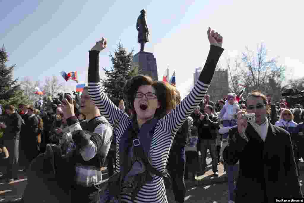 Женщина празднует в Севастополе 18 марта 2014 года во время прямой трансляции выступления Путина после результатов непризнанного миром «референдума». Российский президент во время обращения обратился к крымчанам как к «гражданам России».