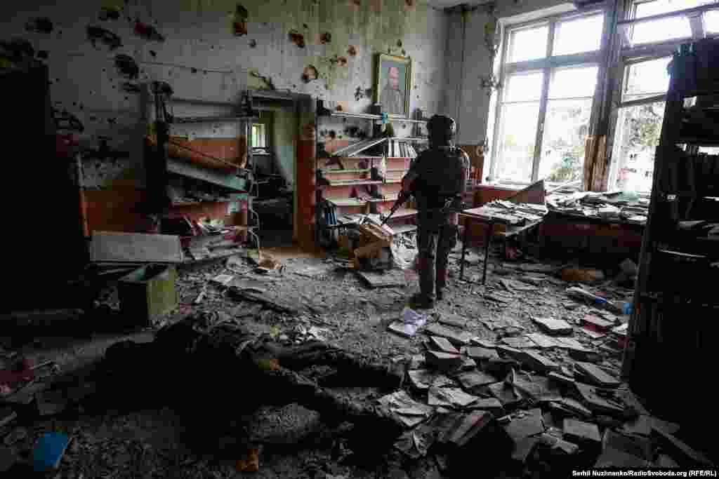 Украинский военный в поврежденном во время сражений здании в селе Благодатное Донецкой области, 17 июня 2023 года
