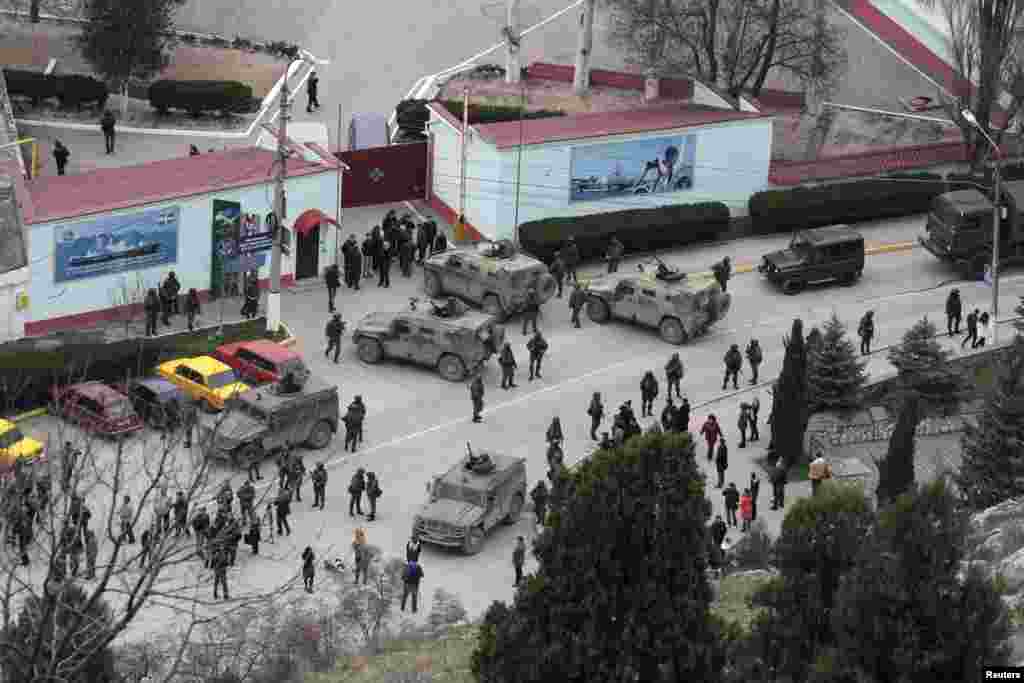Российские солдаты и техника без опознавательных знаков окружают крымскую пограничную базу в Балаклаве, 1 марта 2014 года. В тот же день пророссийский премьер-министр Крыма обратился к Кремлю с просьбой «оказать помощь в обеспечении мира и спокойствия» в Крыму. 