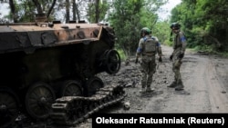 Ukrajinski vojnici pored uništenog ruskog BMP-2 u selu Storoževe u Donjeckoj oblasti, 14. jun 2023. 
