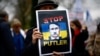 Мужчина на акции протеста с изображением Владимира Путина в виде Адольфа Гитлера у посольства России во Франции. Париж, 17 марта 2024 года