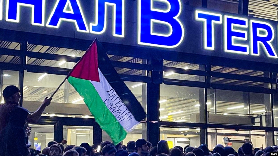 A local man waves a Palestinian flag during a rally at the Makhachkala airport after the arrival of a scheduled flight from Tel Aviv on October 29.