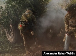 A Russian soldier wears a Soviet flag patch as he fires a howitzer in Ukraine's Luhansk region on October 4.