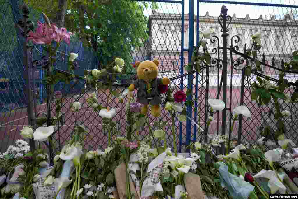 Цветы и игрушки у здания школы в Белграде, Сербия, 4 мая 2023 года. 13-летний подросток открыл стрельбу в своей школе, погибли несколько детей и охранник. Прибывшая на место полиция задержала подростка. AP/Darko Vojinovic 