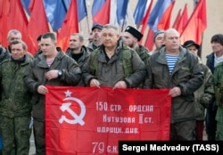 Mobilized Russian conscripts and volunteers hold the Soviet victory banner as they prepare to depart Orenburg, Russia, in October 2022.