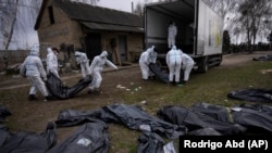 Во время эксгумации погибших гражданских людей в результате российской оккупации. Город Буча в Киевской области, 12 апреля 2022 года