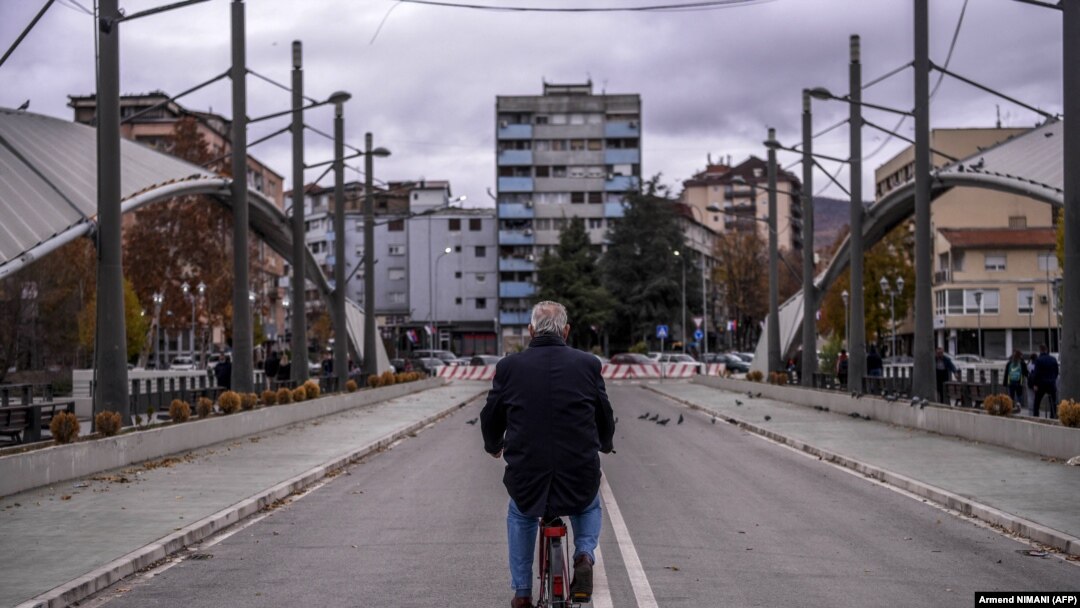Biciklista prelazi most preko reke Ibar, u pravcu Severne Mitrovice jedne od deset opština sa srpskom većinom na Kosovu i one koja bi se trebalo naći unutar buduće Zajednice srpskih opština. Fotografija od 9. novembra 2021.