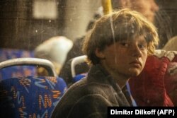 Foarte multe dintre persoanele evacuate din Mariupol au ajuns la Zaporojie. În fotografie: un băiat se uită pe fereastra unui autobuz ajuns la o zonă de înregistrare și procesare pentru persoanele strămutate intern din Zaporojie, pe 8 mai 2022.