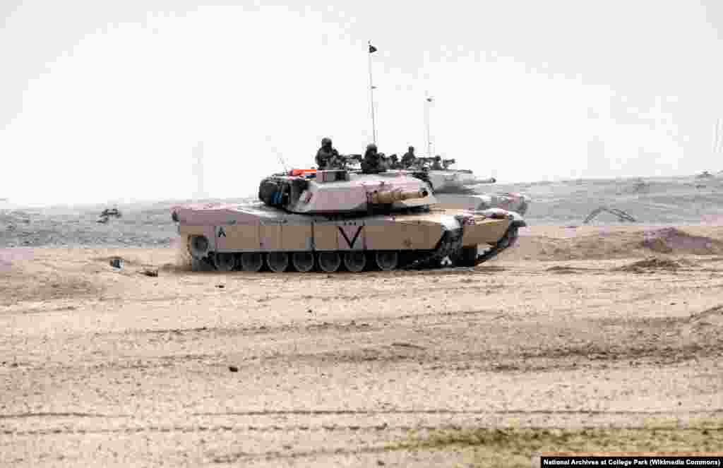 Два основных боевых танка M1A1 Abrams корпуса морской пехоты движутся по пустыне во время наземной фазы операции «Буря в пустыне» 24 февраля 1991 года.