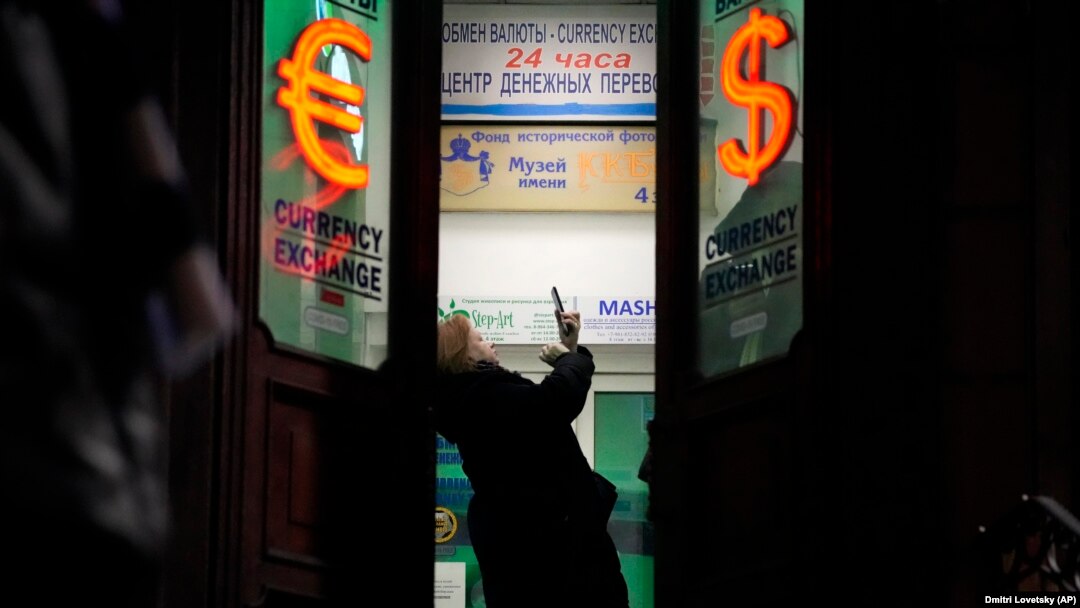 Žena u Sankt Petersburgu čeka u redu u menjačnici 25. februara 2022, dan nakon početka invazije na Ukrajinu. Građani Rusije su preplavili banke i pohrlili na bankomate nakon što je Zapad najavio i počeo sa sprovođenjem oštrih sankcija toj državi. 