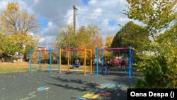Kyrylo (left) and some friends play on the swings at the Raze de Soare center.