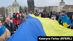 Украинцы разворачивают флаг своей страны на Карловом мосту в Праге 19 января этого года
