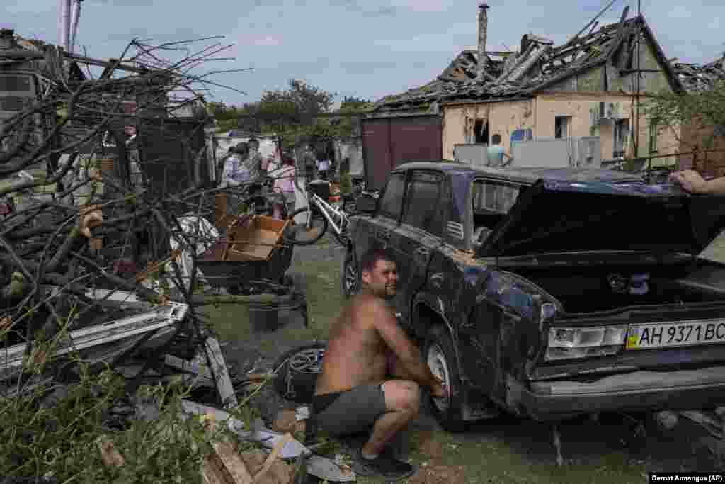 Тұрғындар шабуылдан аман қалған заттарын жинап жатыр. 