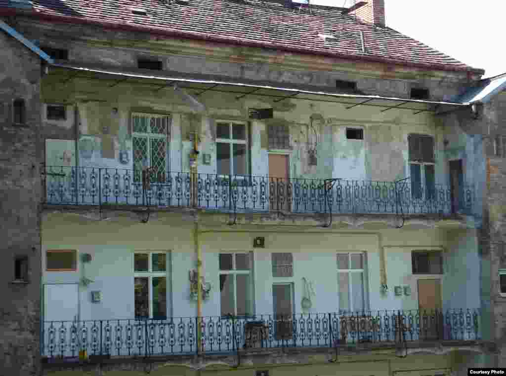 Такой балкон называется "павлач" - это самая характерная особенность жижковской архитектуры. Дома с павлачами строили на рубеже XIX-XX веков, социальное жилье для небогатых: небольшие квартиры выходили на общую терассу с общими же коммунальными услугами. В Жижкове теперь есть и популярное у студентов кафе "Павлач"; а балконы кажутся милыми историческими пустячками.