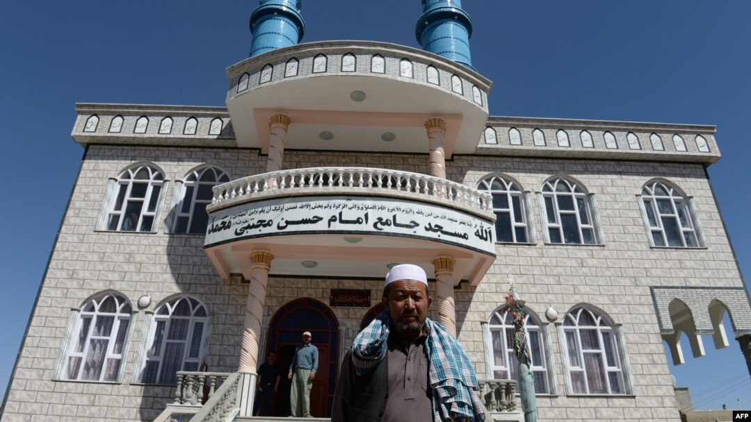 Men stand in front of a Shi'ite mosque in Kabul where intelligence forces killed what they say were two Pakistani terrorists in police uniforms. 