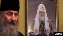 Предстоятель УПЦ (МП) Онуфрій (на передньому плані) у 2022 році заявив про розрив церкви із РПЦ, яку очолює патріарх Кирило (на портреті ззаду)