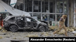 La 10 ianuarie, un anchetator se plimbă pe lângă un magazin avariat în urma bombardamentelor din orașul ocupat Donețk, pe care autoritățile locale instalate în Rusia le-au numit un atac militar ucrainean. 