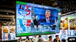 TV ekran koji prikazuje preliminarne rezultate o američkim izborima visi u restoranu u Hong Kongu 6. novembra 2024.