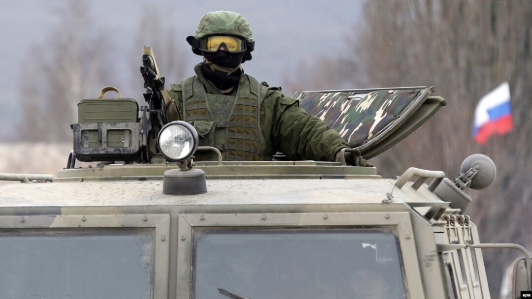 Вооруженный человек в военной форме в селе Перевальное близ Симферополя. 4 марта 2014 года. После аннексии Крыма Москвой президент Владимир Путин признает, что в Крыму действовали российские военные.