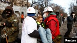 Medici voluntari transportă o jurnalistă rănită în cicnirile cu poliția.