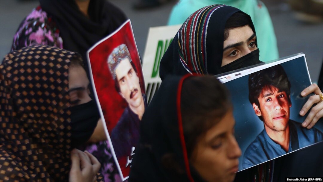 Relatives hold portraits of disappeared family members during a protest in Karachi in August.