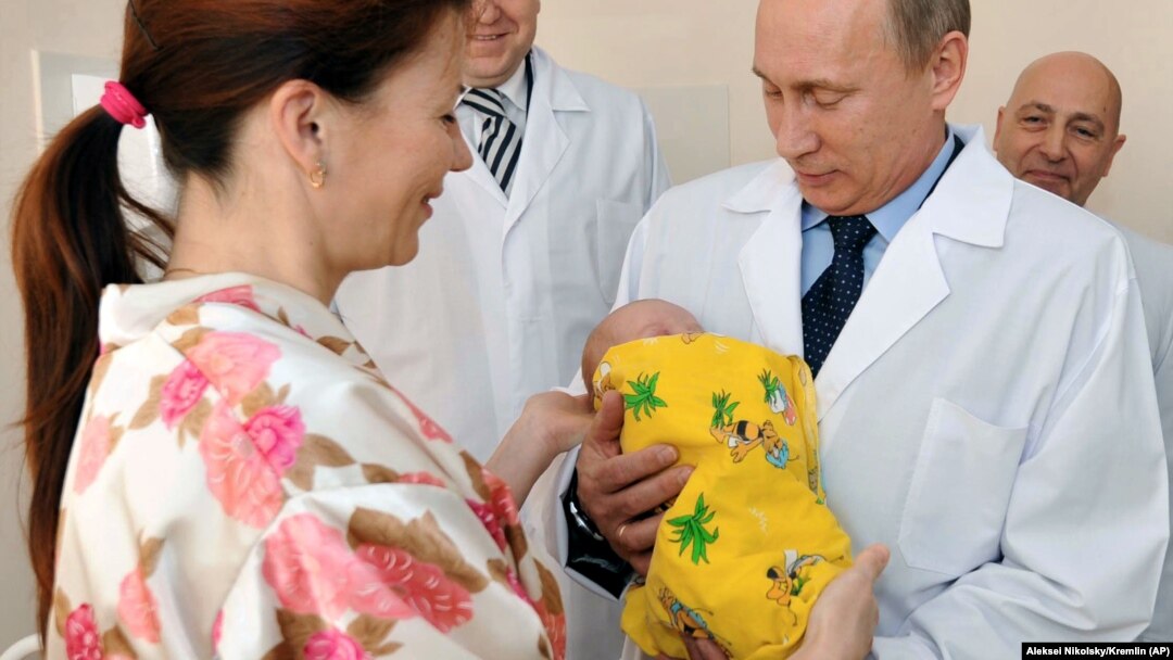 Vladimir Putin Kalininqraddakı doğum evini ziyarət edərkən yeni doğulmuş uşağı qucağında tutur