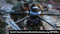 Ukrajinski vojnici pričvršćuju municiju na modifikovani dron, region Donjecka, oktobar 2024.