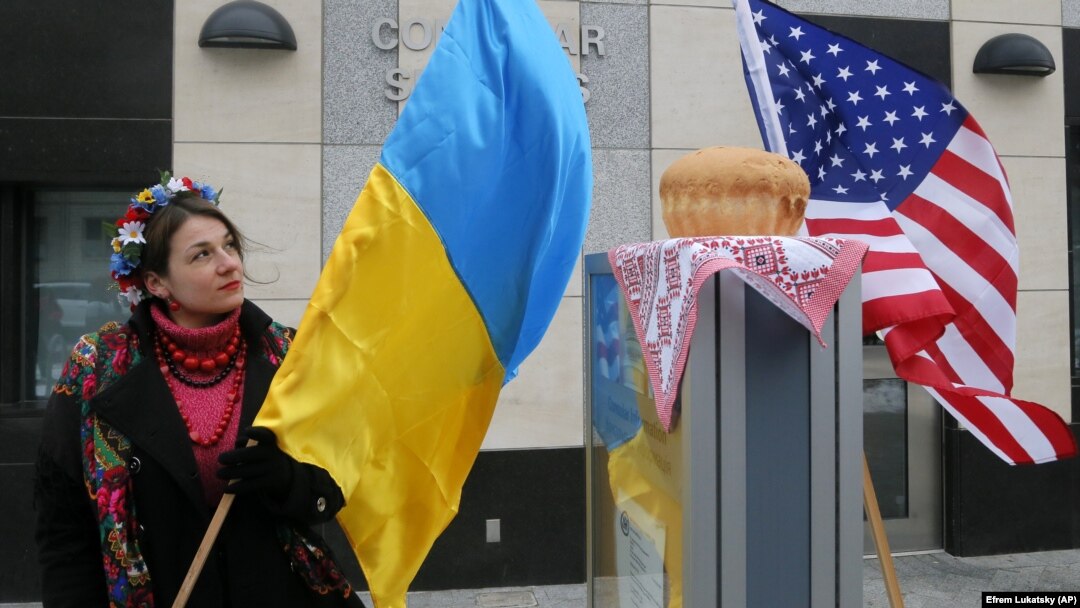 Ілюстративне фото. Жінка з прапором України біля посольства США у Києві. За окремими повідомленнями, Вашингтон може запровадити санкції проти окремих українських чиновників.
