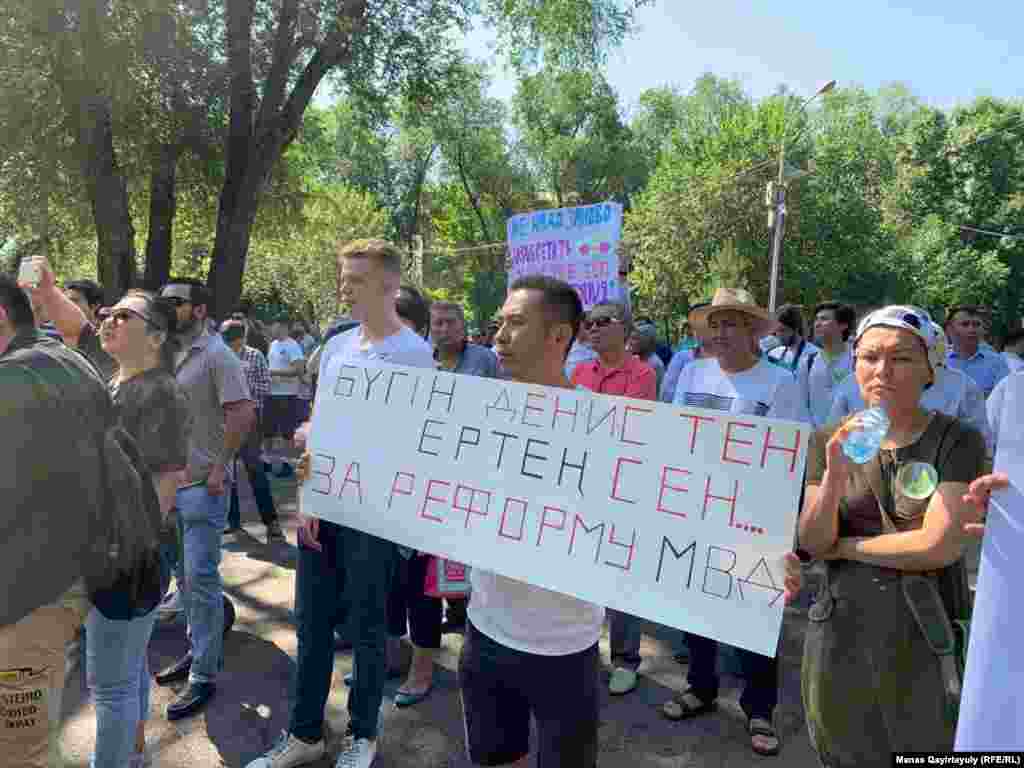 Участник с плакатом, надпись на котором содержит призыв реформировать МВД. Инициатива реформы силового ведомства была выдвинута в прошлом году, после убийства фигуриста Дениса Тена в центре Алматы. По версии полиции, он стал жертвой воров, снявших зеркала с его автомобиля.
