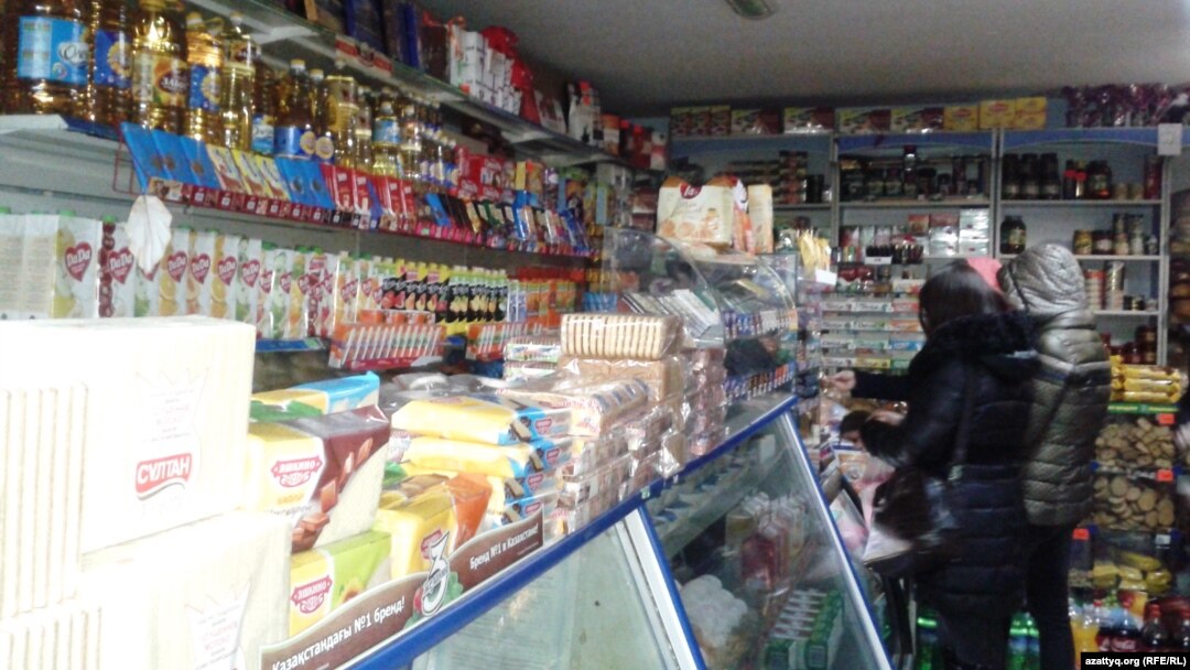 Покупатели у прилавка в небольшом магазине в Алматы.