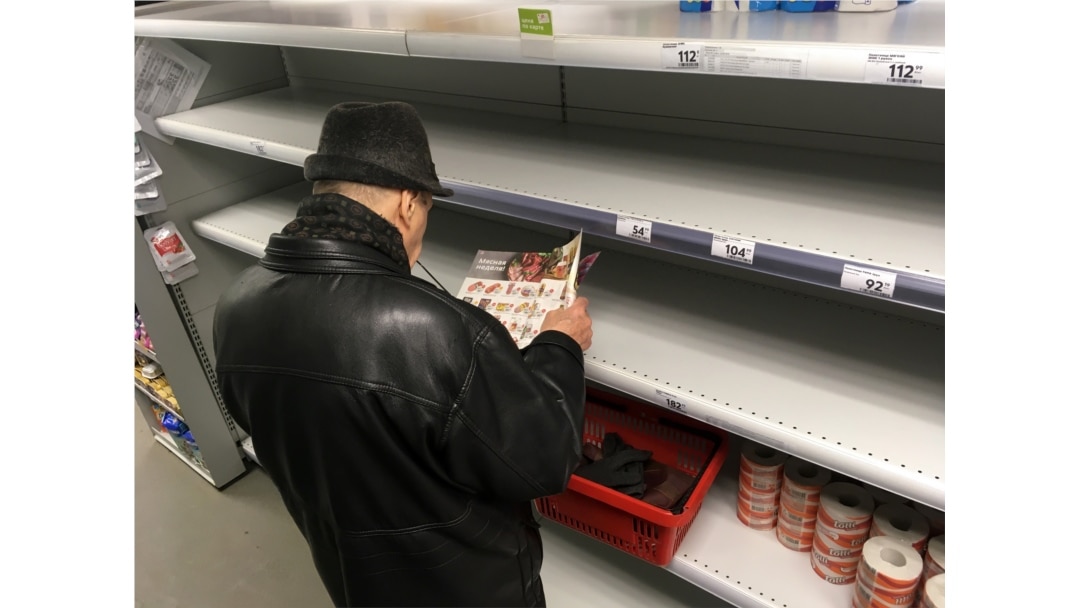 A man stands in front of empty shelves in a supermarket in Moscow on March 17.