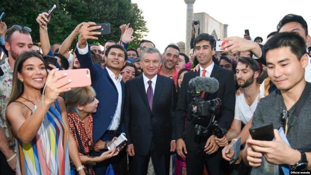 In a photo from the president's website, President Shavkat Mirziyoyev (center) poses with bloggers and journalists in Samarkand in August 2019.
