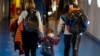 O familie purtând măști chirurgicale, pe aeroportul Otopeni din Bucuresti