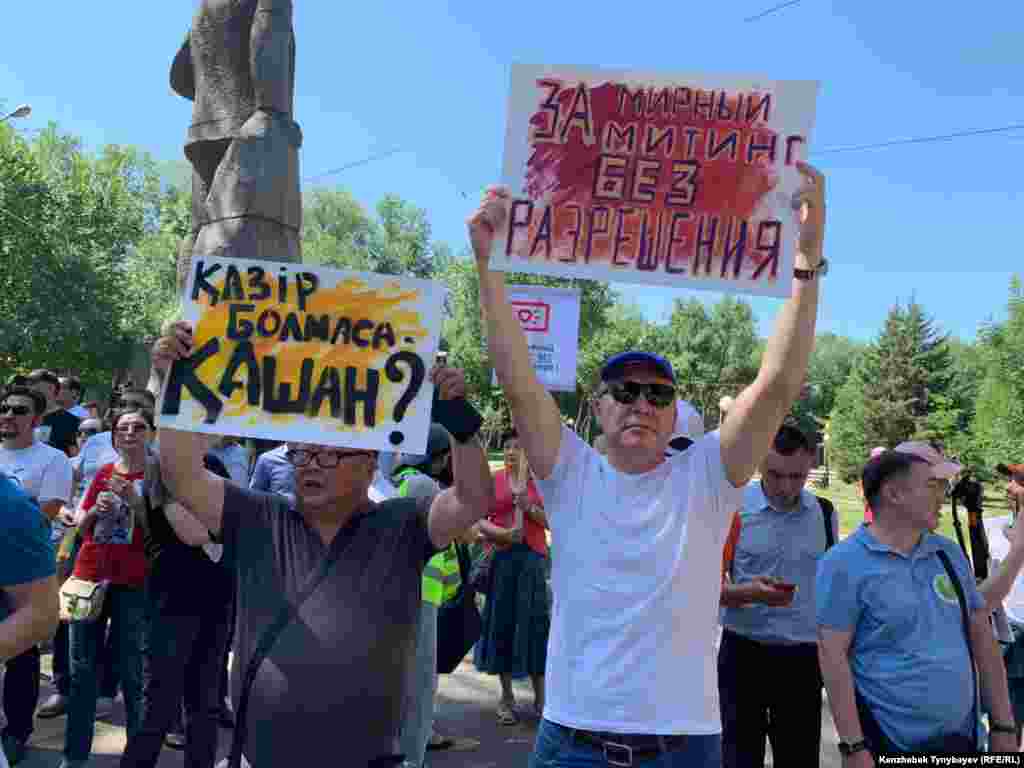 Плакат "За мирный митинг без разрешения" в руках Серикжана Мамбеталина, участника форума "Жаңа Қазақстан" ("Новый Казахстан"), объявившего в этом месяце о сворачивании деятельности.