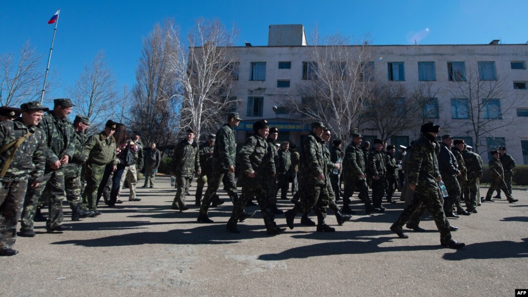 Ukrainian soldiers walk out of a Ukrainian air force base in the small Crimean city of Novofedorivka after it was stormed by pro-Russian protesters on March 22. 
