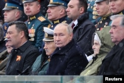 Президент России Владимир Путин, иностранные гости и российские военные смотрят военный парад на Красной площади в Москве, Россия, 9 мая 2024 года