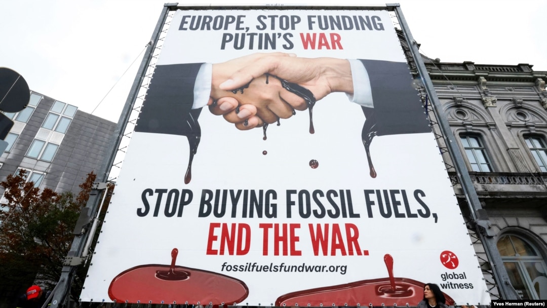 Un panou publicitar pe care scrie „Europa, nu mai finanța războiul lui Putin. Nu mai cumpărați combustibili fosili, puneți capăt războiului”, afișat în 2022 în fața Parlamentului European din Bruxelles.