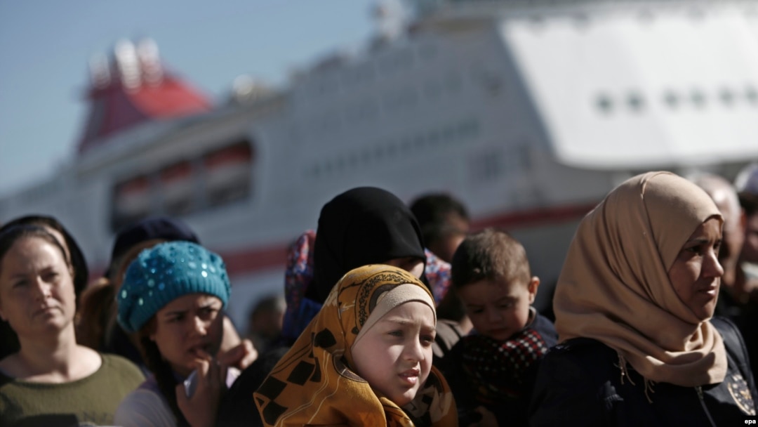 Refugees and migrants wait to receive food distributed by the Greek Red Cross at the port of Piraeus, near Athens. (file photo)