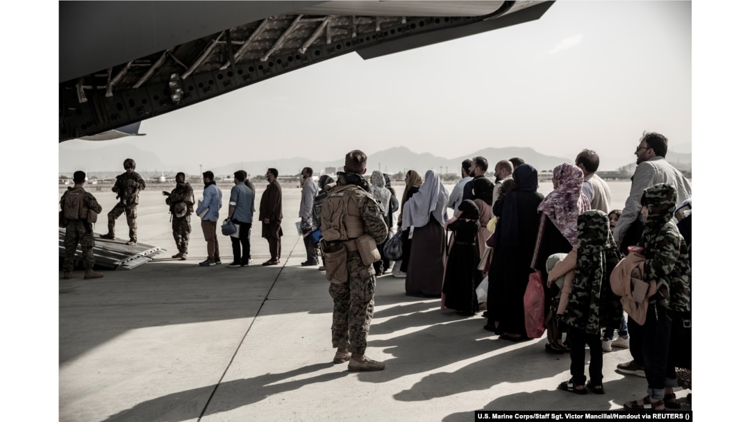 Evacuees wait to board a Boeing C-17 Globemaster III during an evacuation at Kabul Airport on August 30, 2021.