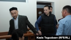 Айыпталушылар Кенжебек Әбішев (сол жақта) пен Алмат Жұмағұлов сот залына келген сәт. Алматы, 26 қыркүйек 2018 жыл.