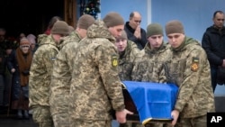 Военные несут гроб с телом погибшего на фронте украинского солдата Андрея Кузьменко во время церемонии прощания в Михайловском соборе Киева. 10 января 2025 года