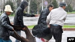 مخالفان دولت یکی از کشته شدگان را حمل می کنند.