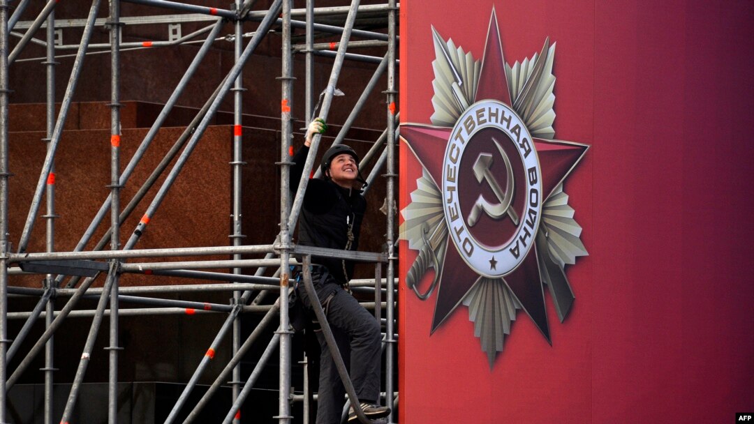 Russian worker installs a banner for the upcoming Victory Day celebrations on Moscow's Red Square, April 27