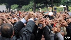 Demonstranti drže svoje ruke sa lisicama na rukama i izvikuju parole ispred MUP-a u Tunisu, 14. januar 2010.