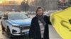 Асхат Ахмедьяров с желтым флагом после того, как его остановили полицейские. Алматы, 8 февраля 2025 года. Фото со страницы Бахытжан Торегожиной в Facebook'е