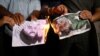 Ljudi pale slike Masooda Azhara, vođe pakistanske militantne grupe Jaish-e-Mohammad, dok slave odluku odbora Vijeća sigurnosti UN-a da Azhara stavi na crnu listu, u Ahmedabadu, Indija, maj 2019. godine