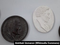 АКШлык ырчы, актёр Поль Робсон жана акын Жоомарт Бөкөнбаевдин гипстен жасалган барельефтери.