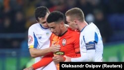 Гравці «Динамо» Микола Шапаренко (л) та Віктор Циганков (п) з гравцем «Шахтаря» Тайсоном (у центрі) після рішення арбітра тимчасово зупинити матч через расизм, Харків, 10 листопада 2019 року
