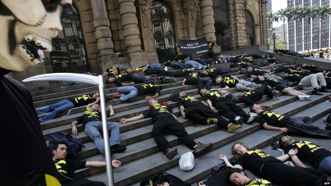 Активисты Greenpeace лежат на ступенях городского театра, изображая жертв радиационной аварии в бразильском городе Гояния, в результате которой 20 лет назад погибло почти 60 человек. Сан-Паулу, 11 сентября 2007 года.